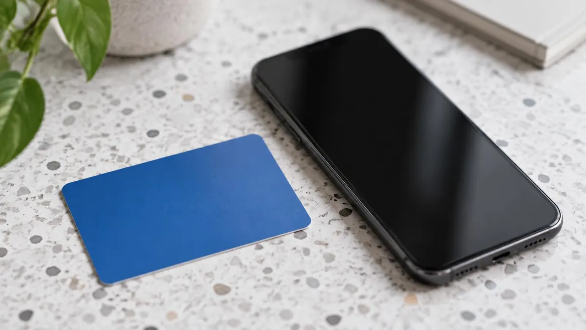 A state driver license and a smartphone with a blank screen on a desk